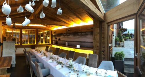 a dining room with a long table and chairs at Boutique Hotel Beau-Séjour & Spa Superior in Champéry