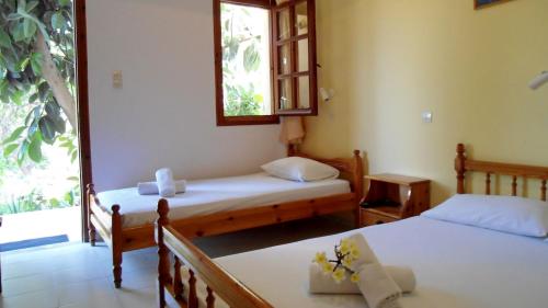 a room with two beds and a window at Katerina Palaiochora in Palaiochóra