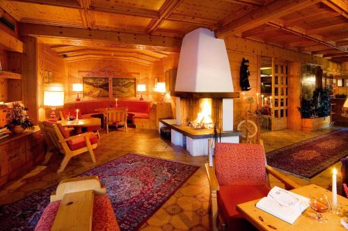 a large room with a living room with a fireplace at Wanderhotel Teiserhof in Funes