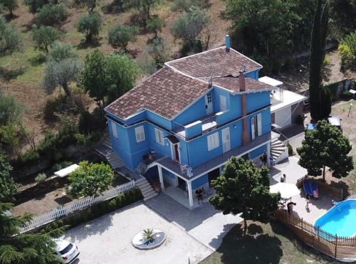 einen Luftblick auf ein blaues Haus mit einem Pool in der Unterkunft La Casa Blu in Mirabella Imbaccari
