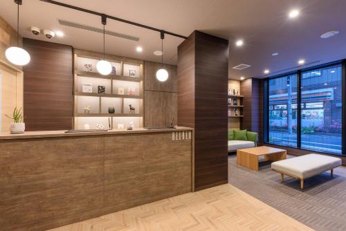 a lobby with a reception desk and a couch at Belken Hotel Kanda in Tokyo