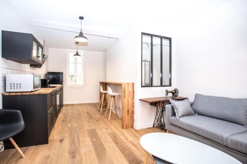 sala de estar con sofá y cocina en Appartement 4 - Standing, moderne et tout équipé - Carmes, Toulouse, en Toulouse