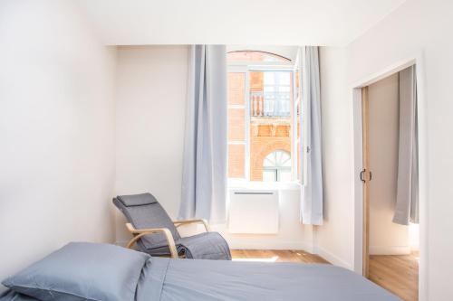 1 dormitorio con silla, cama y ventana en Appartement 4 - Standing, moderne et tout équipé - Carmes, Toulouse, en Toulouse