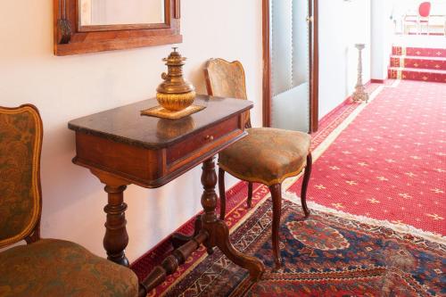 an old wooden table and chair in a room at Villa Excelsior Hotel & Kurhaus in Bad Gastein
