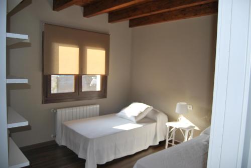 a bedroom with a bed and a window at The Cool Houses in Llanes
