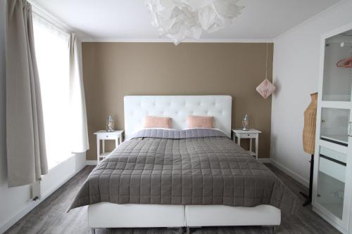 a bedroom with a large bed and two tables at Elbperle94 in Hamburg
