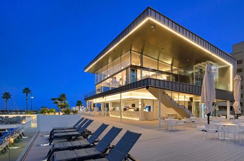 a large glass building with lounge chairs in front of it at Sol Torremolinos - Don Pablo in Torremolinos