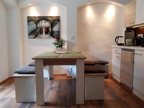 einen Tisch in einer Küche mit einem Gemälde an der Wand in der Unterkunft Lindes Ferienwohnung in Dinkelsbühl