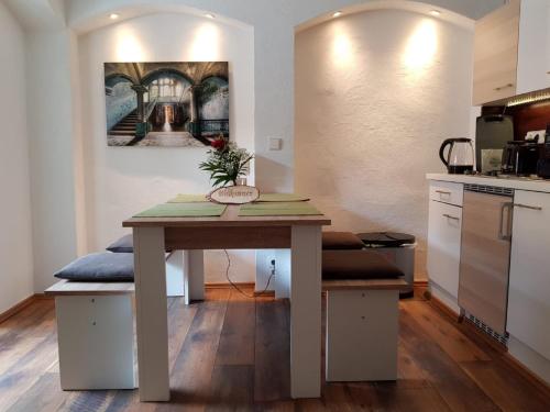 a table in a kitchen with a painting on the wall at Lindes Ferienwohnung in Dinkelsbühl