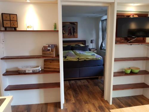 a bedroom with a bed in a room with shelves at Lindes Ferienwohnung in Dinkelsbühl