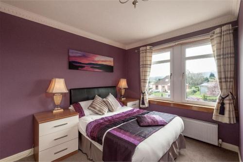 a purple bedroom with a bed and a window at Hillhouse in Edinburgh