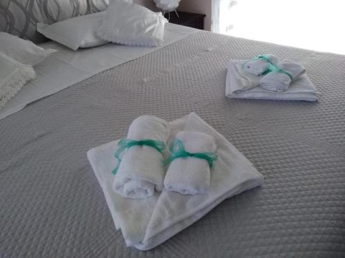 two folded towels are sitting on a bed at Corte dei Giorgi in Vernole