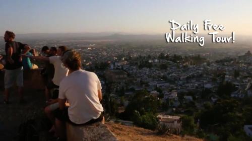 a group of people standing on a hill looking at a city at ECO Hostel in Granada