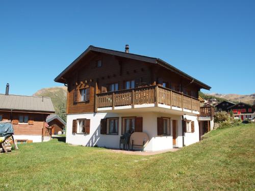 a house with a balcony on top of a hill at Chalet Silberdistel in Rosswald