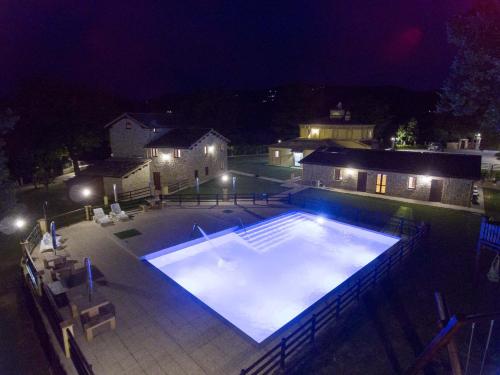 a large swimming pool at night with lights at BorgoPratole CountryHouse in Cingoli