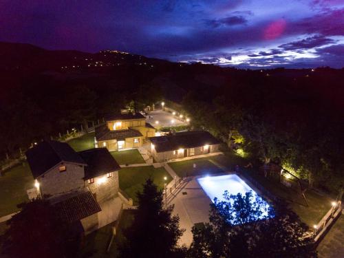 an aerial view of a house with a pool at night at BorgoPratole CountryHouse in Cingoli