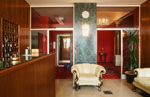 a lobby with a waiting room with a chair at Villa Excelsior Hotel & Kurhaus in Bad Gastein