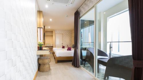 a hotel room with a bed and a balcony at Anda Beachside Hotel in Karon Beach