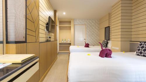 a hotel room with two beds and a bathroom at Anda Beachside Hotel in Karon Beach