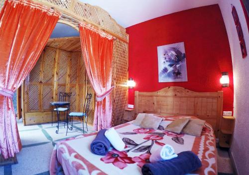 Schlafzimmer mit einem großen Bett mit roten Wänden in der Unterkunft Riad Les Chtis D'Agadir in Agadir