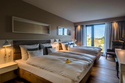 カンプ・リントフォルトにあるWellings Parkhotelのベッドが2つと大きな窓があるホテルの部屋