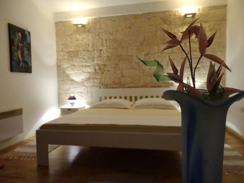 a bedroom with a bed and a vase with a plant at Apartment Naita in Sinj