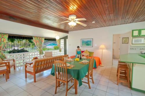 a dining room and living room with a table and chairs at Lance Aux Epines Cottages in Lance aux Épines