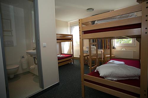 a room with two bunk beds and a bathroom at CVJM Jugendgästehaus Berlin in Berlin