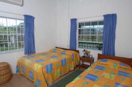 a bedroom with two beds and a window at Lance Aux Epines Cottages in Lance aux Épines