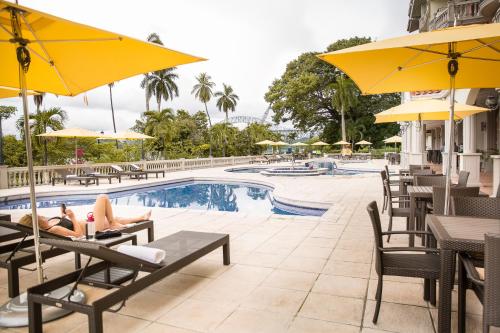 a woman laying on chairs next to a swimming pool at Radisson Hotel Panama Canal in Panama City
