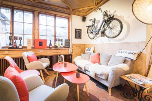 a living room with a couch and a bike hanging on the wall at Boutique Hotel Beau-Séjour & Spa Superior in Champéry
