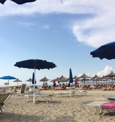 a group of chairs and umbrellas on a beach at Bellavista Qerret Apartments in Golem