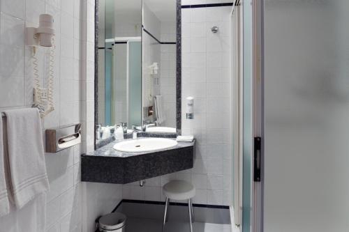 a bathroom with a sink and a mirror at City Hotel & Suites in Foligno