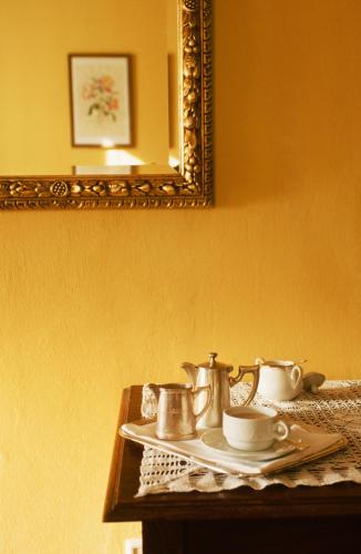 a table with three tea pots and a mirror at Villa Excelsior Hotel & Kurhaus in Bad Gastein