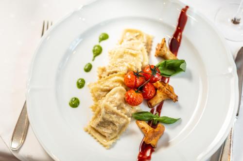 a white plate with food on a table at Hotel Bären in St. Moritz