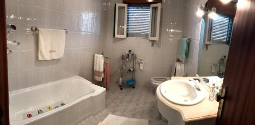 uma casa de banho com uma banheira, um WC e um lavatório. em Holiday House, São Roque do Pico em Cais do Pico