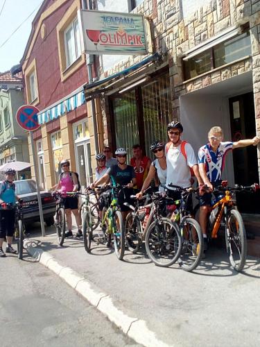 a group of people riding bikes down a street at Hostel Olimpik in Negotin