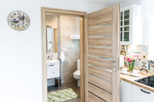 a bathroom with a toilet and a wooden door at Blisko Lasu in Ustrzyki Dolne