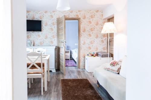 ウストシキ・ドルネにあるBlisko Lasuのテーブルとベッドルームが備わる小さな客室です。