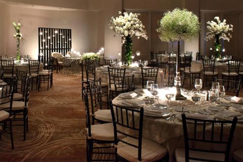 a banquet hall with tables and chairs with white flowers at Krystal Monterrey in Monterrey