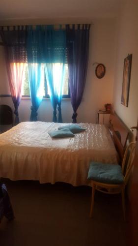 a bedroom with a large bed with blue curtains at appartamento Lory in Campomarino