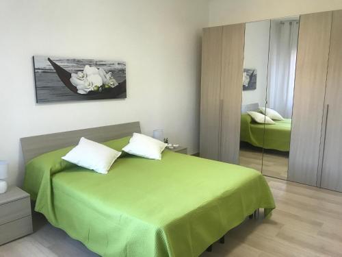 una camera con letto verde e specchio di Baia Taormina Apartment a Giardini Naxos