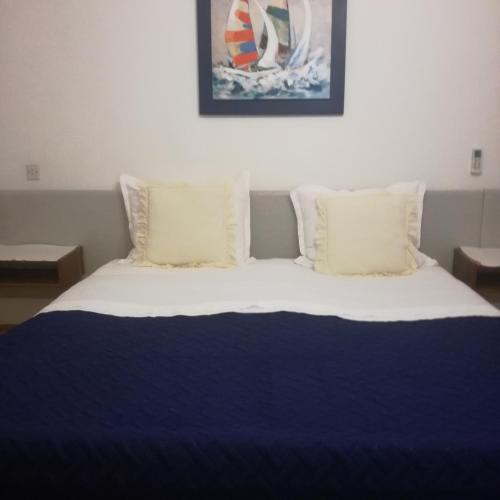 a bed with a blue blanket and pillows at Apartman Stipe in Jelsa
