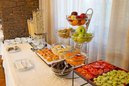 a buffet with bowls of fruits and vegetables on a table at Hotel Ideal in Sirmione
