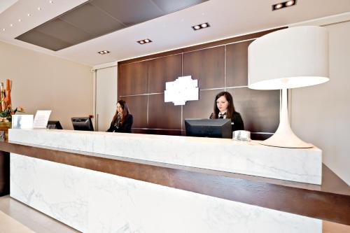 two women sitting at a reception desk at Italiana Hotels Cosenza in Cosenza