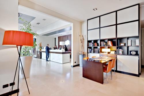 a man walking through a living room with a table at Italiana Hotels Cosenza in Cosenza