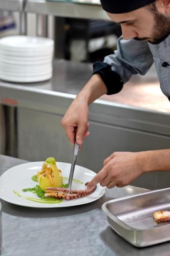 a man cutting a plate of food with a fork and knife at Italiana Hotels Cosenza in Cosenza