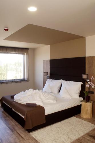 a bedroom with a large bed with white pillows at Fitromax Sportpanzió Ajka in Ajka
