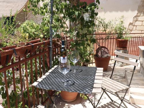 a table with a bottle and a wine glass on a balcony at Casa Vacanze "A Machina Ro Ghiaccio" in Noto