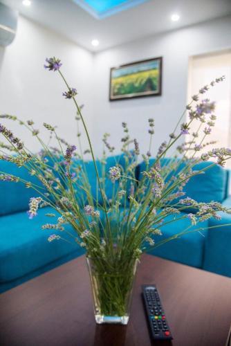 a vase of flowers sitting on a table with a remote control at GardenLux Vrdnik in Vrdnik